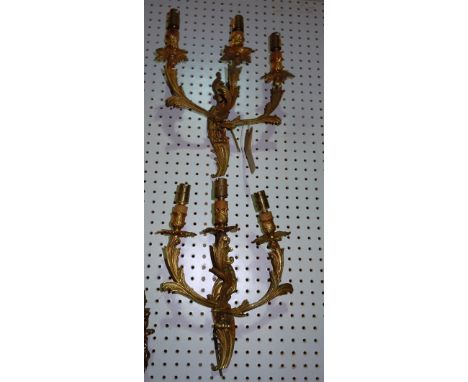 Lighting comprising;a set of four 20th century gilt metal three branch wall lights of Rococo design, (4). H10