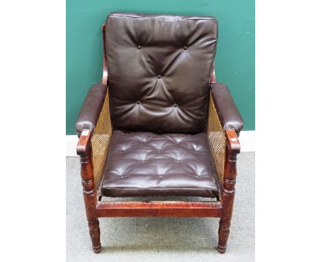 A Victorian mahogany and caned bergère library armchair, later button upholstered back and arms, on turned tapering supports,