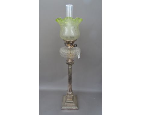 An Edwardian silver plated oil lamp of Corinthian column form, with a cut clear glass reservoir, Hinks Duplex burner and a la