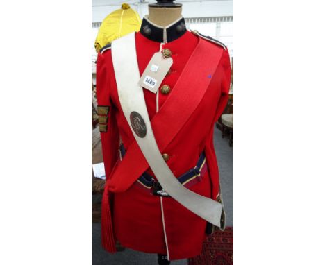 A British military officer's red tunic, sash and belt displayed on an ebonised wood and shaped tailor's dummy by Siegel Stock