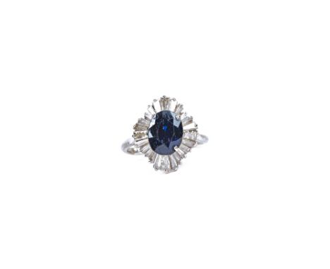 A white gold, sapphire and diamond ring, claw set with the oval cut sapphire at the centre in a radiating surround, mounted w