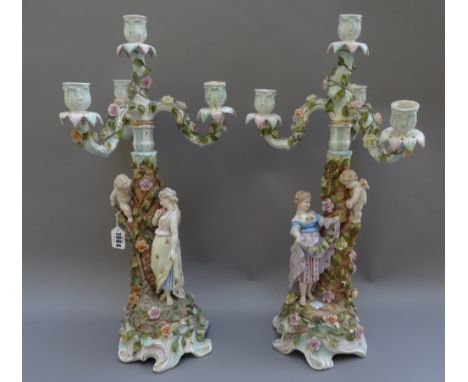 A pair of Sitzendorf four-light candelabra, late 19th century, each modelled with a young woman and a putto around a tree, be