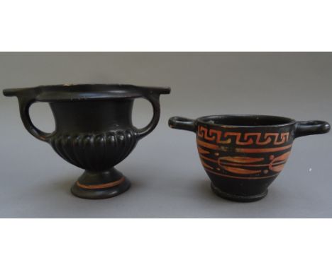 A South Italian black glazed skyphos, circa 300 B.C., decorated in red with a band of leaves and berries beneath a key patter