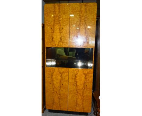 A 20th century satinwood and ebonised drinks cabinet with central mirrored back shelf and two door cupboard above and below, 