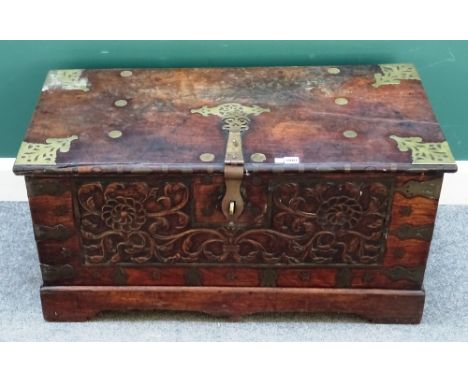 A 19th century Zanzibar type brass mounted teak rectangular trunk, with floral carved front panel, 96cm wide x 49cm high x 46