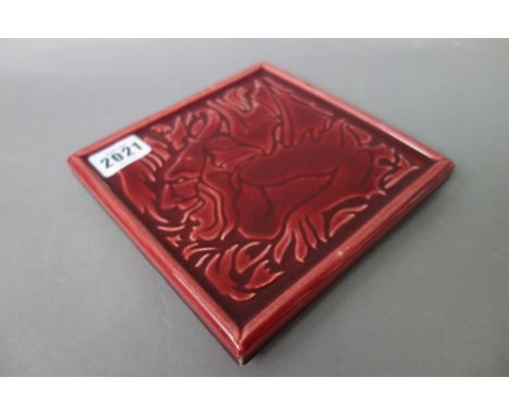 A.J.C Edwards pictorial tile, red ground, relief moulded with a dual anthropomorphic picture and raised on four moulded feet,