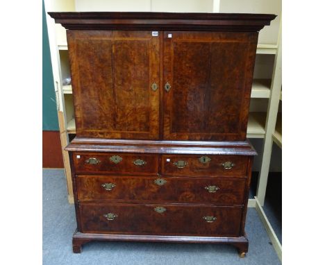 A George I chevron banded figured walnut cabinet on chest, the pair of doors enclosing a fitted interior over two short and t