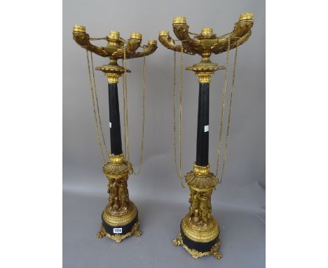 A pair of Empire style gilt metal five branch candelabra, 20th century, the moulded sconces of oil lamp form, united by chain