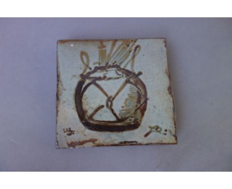 A Bernard Leach (1887-1979) pottery tile, painted with a wicker bound pot containing paint brushes, painted marks (10cm x 9.5