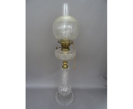 An Edwardian cut glass oil lamp, with matching reservoir, gilt metal burner and a later clear glass shade of globular form, 7