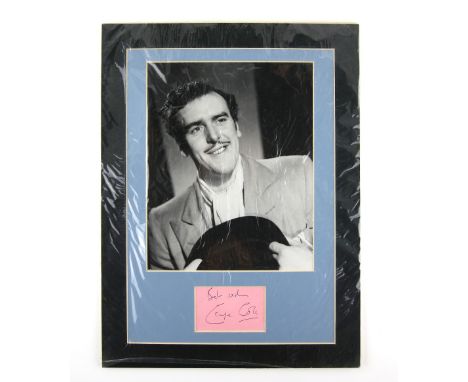 George Cole autograph mounted underneath a black and white photo of Cole in the guise of “Flash Harry” from the St Trinian’s 