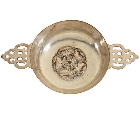 AN ARTS AND CRAFTS SILVER PLATED PORRINGER BY THE DUCHESS OF SUTHERLAND'S CRIPPLES' GUILD, CHASED WITH A ROSE TO THE WELL, PI