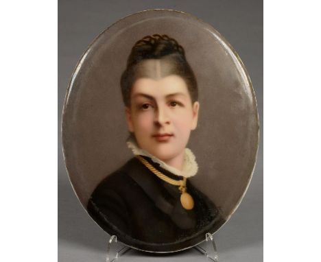 A BERLIN PORCELAIN PLAQUE, OUTSIDE DECORATED, PAINTED WITH A PORTRAIT OF A YOUNG WOMAN IN BLACK DRESS, A GOLD LOCKET ABOUT HE