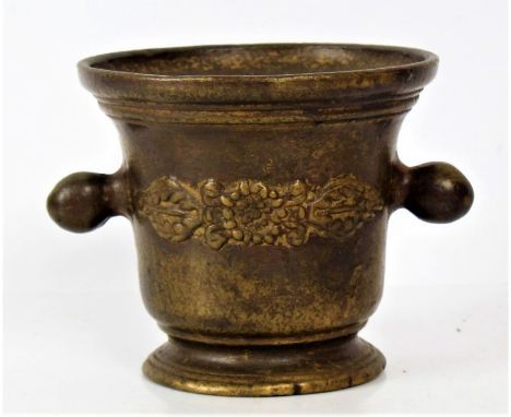 A 19th century bronze mortar the body decorated with a floral motif and with a pair of handles either side, 14cm high&nbsp;