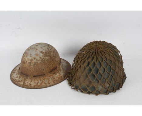 M1 type combat helmet with liner, chin strap, and net helmet cover, together with a WW2 British Civil Defence Zuckerman helme