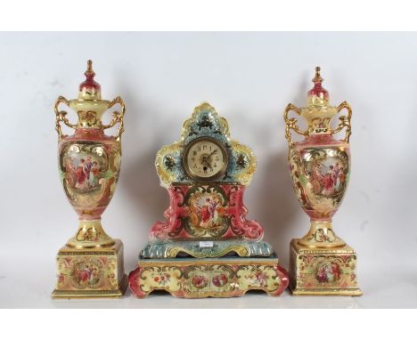 Royal Crown Coronia porcelain mantle clock garniture, decorated with a pink and blue ground set with various panels with clas