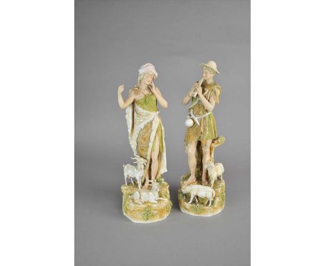 A pair of Royal Dux Shepherd and Shepherdess figures late 19th/early 20th century modelled clad in pelts, the male figure pla