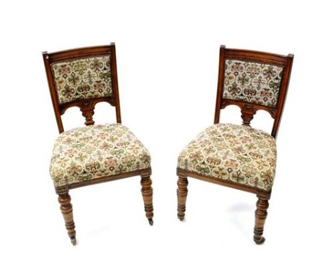 A set of six Victorian oak dining chairs, circa 1880, each with later upholstered panel back and overstuffed seat and raised 