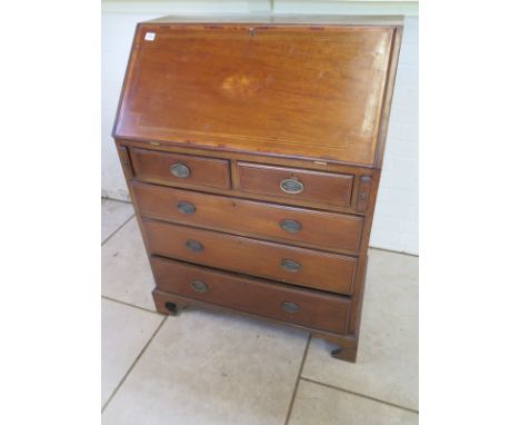 An Edwardian inlaid mahogany bureau with a good fitted interior above two short and three long drawers, on shaped bracket fee