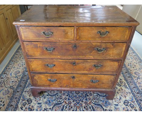 A Georgian walnut chest with a quarter veneered top and two short over three long drawers on bracket feet - 88cm H x 90cm x 5