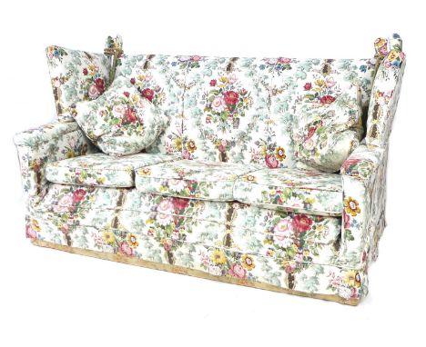 A Knowle style three piece suite, in floral pattern upholstery, comprising a three seater sofa with drop arms, 180 by 91 by 1