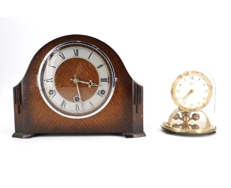 A 1930s oak cased mantle clock, striking and chiming on gongs, and a German Kundo torsion clock, under a glass dome, [both ru