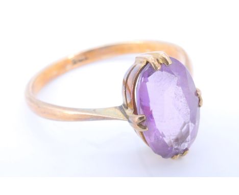 An early 20th Century amethyst and 9 ct yellow metal finger ring, the 10 x 6.5 mm marquise cut stone set on a gallery of four