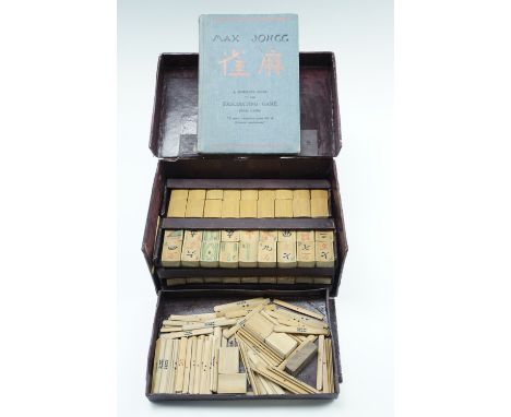 A vintage bamboo mahjong set, including its instruction booklet and a set of hand made bone dice