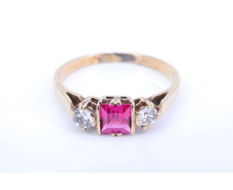 A 1920s ruby and chrysoberyl 9 ct yellow metal ring, having a square cut ruby flanked by two white brilliant cut stones, betw