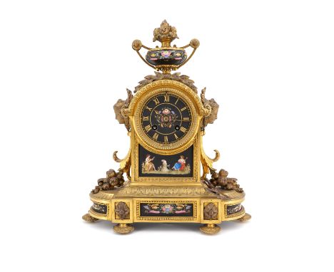 A 19th Century French gilt brass and enamel mantle clock, having a drum movement striking on a bell, the face being black mat