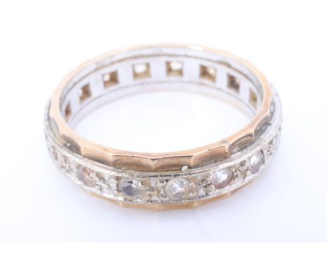 A 1960s 9 ct gold eternity ring, set with 17 chrysoberyl brilliants in a central white metal band on a scalloped shank, Birmi