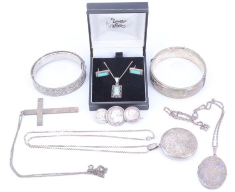 A group of silver jewellery comprising two hinged bangles, a locket and pendant cross, together with a white metal locket, co