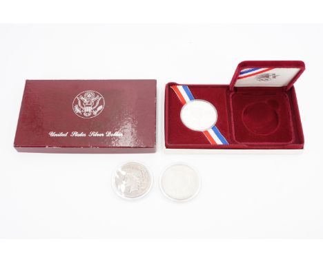 A cased silver proof 1983 US "XXIII Olympiad Los Angeles" 1 Dollar coin, together with two silver US 1922 "Peace" Dollars 