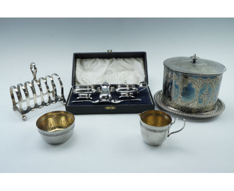 An Edwardian oval bodied biscuit barrel, a cased Walker and Hall electroplated condiment set, a toast rack and a cream jug wi