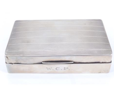 A 1920s silver table cigarette box, its subtly domed lid decorated with banded engine turning, 15 cm x 9 cm x 3.5 cm, 383 g (