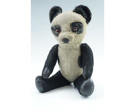 A vintage toy panda Teddy bear, having glass eyes, articulated limbs with leathercloth pads and a growler mechanism, second q