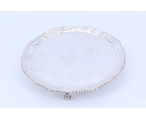 A George III style silver salver, having a Chippendale style rim, on three scroll feet, Asprey &amp; Co Ltd, London, 1978, 21