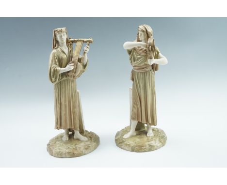 A pair of Royal Worcester blush ivory Egyptian revival figurines, being a lady playing a tambourine and a gentleman playing a