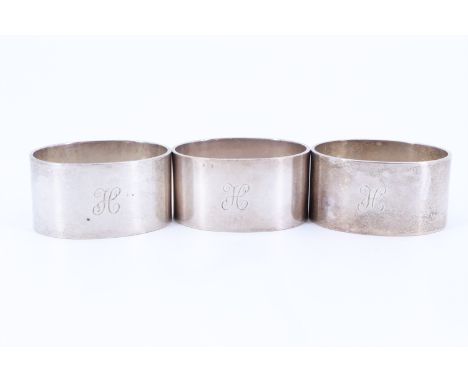 A trio of 1930s heavy silver napkin rings, of oval section and bearing the engraved initial H, John Rose, Birmingham, 1937, 1
