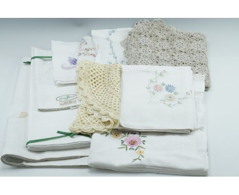 A quantity of vintage embroidered table cloths, crochet work, linen table cloths and napkins