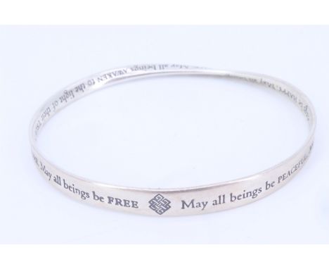 A British Museum silver "Mobius strip" bangle inscribed with a Buddhist Metta prayer "May all beings be peaceful. May all bei