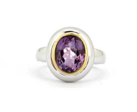 A matching 18ct white gold (stamped 750) ring set with oval cut amethyst, (N).