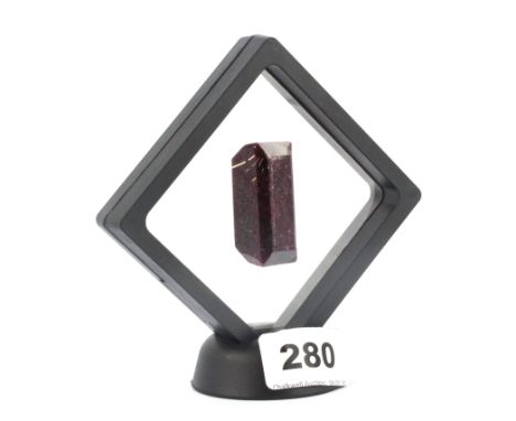 An unmounted step cut ruby in a perspex display stand, approx. 251.25ct.