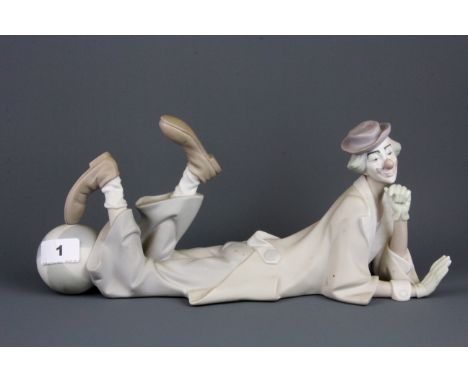 A Lladro bisque clown figure, L. 36cm, H. 16 cm.