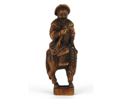A finely carved fruitwood netsuke of a man riding a horse, H. 9cm.