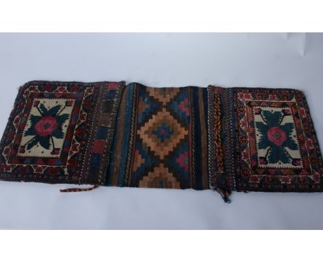 An early 20th Century double-sided carpet and flatweave Baluch saddle bag face; 125 cms x 36 cms; a double-sided saddle bag f