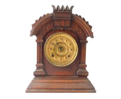 A late 20thC mahogany mantel clock, the arched pediment top on column supports, with a brass numeric dial, on a stepped foot,