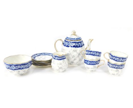 An early 20thC Coalport part tea service, decorated on a blue and white ground flowers, picked out in gilt, comprising teapot