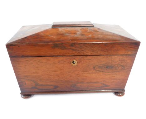 A 19thC rosewood tea caddy, the canted top, on bun feet, with a partially fitted interior, 22cm high, 30cm wide, 16cm deep.