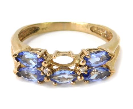 A 9ct gold dress ring, set with three diamond shaped pale blue stones, on rubbed shoulders, ring size P, 2.9g (one stone miss